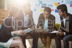 Businesswoman discussing with colleagues over digital tablet