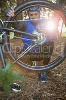 Male mountain biker fixing his bike chain