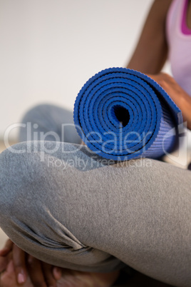 Woman holding exercise mat