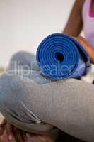 Woman holding exercise mat