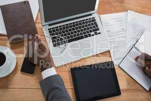 Businessmans hand over laptop, digital tablet, mobile phone and organizer