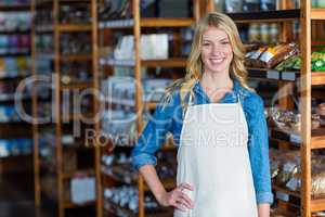 Portrait of smiling female staff standing with hand on hip