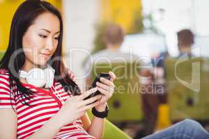 Beautiful businesswoman using cellphone at creative office