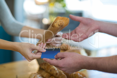 Waitress giving parcel to customer at counter