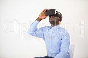 Man sitting on chair and using virtual reality headset