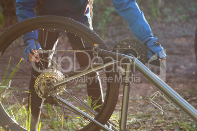 Male mountain biker fixing his bike chain