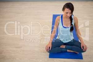 Woman meditating on exercise mat