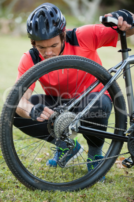 Male mountain biker fixing his bike chain