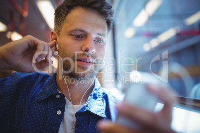 Handsome man listening music on mobile phone