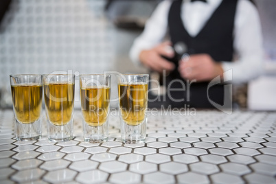 Glasses of whisky on bar counter