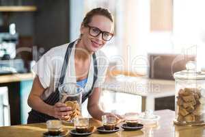 Smiling waitress working at counter in cafÃ?Â©