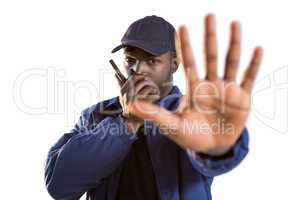 Confident security talking on walkie talkie and making hand stop gesture