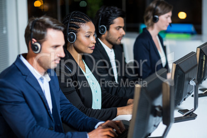 Colleagues with headsets using computer at office