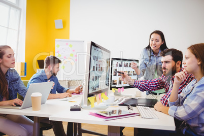 Businessman showing computer screen to coworkers