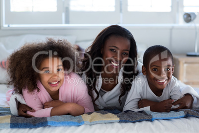 Mother with their children lying on bed
