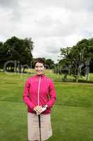 Woman standing with golf club in golf course