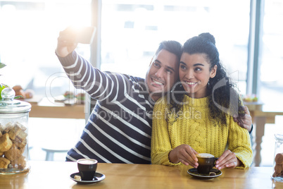 Young couple taking selfie in cafeteria