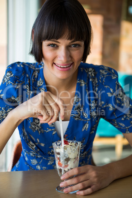 Portrait of smiling woman having dessert