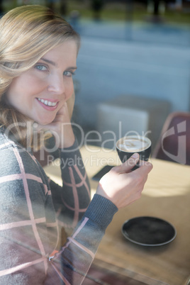 Woman having coffee in cafeteria