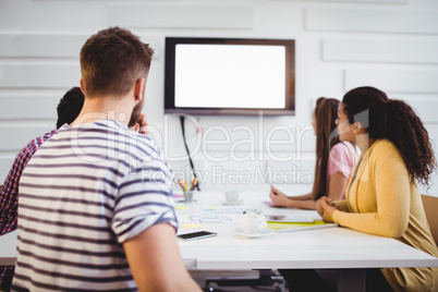 Partners watching at television at creative office