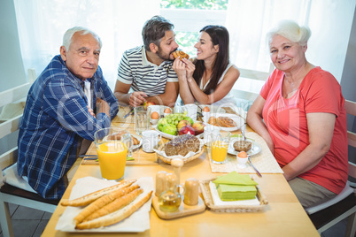 Happy couple having breakfast with their parents