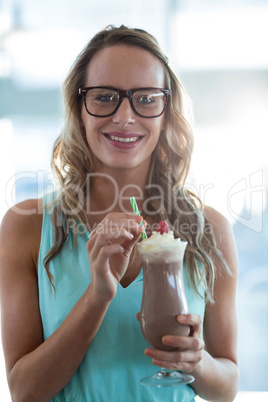 Portrait of woman drinking milkshake with a straw