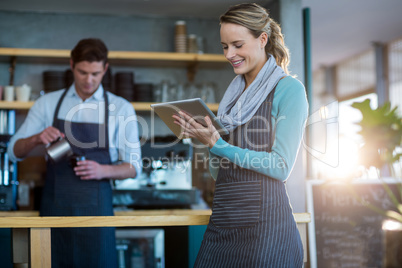 Waitress using digital tablet at counter