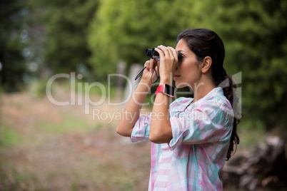 Female hiker looking through binoculars