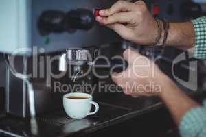 Waiter making cup of coffee