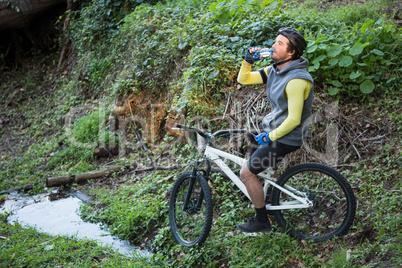 Male mountain biker drinking water