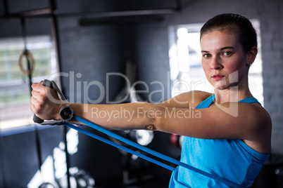 Portrait of female athlete stretching resistance band