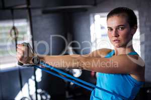 Portrait of female athlete stretching resistance band