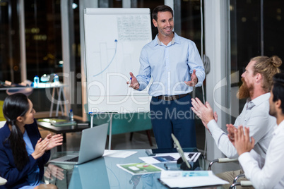 Coworkers applauding a colleague after presentation