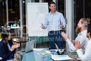 Coworkers applauding a colleague after presentation