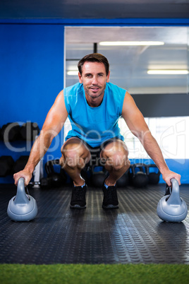 Portrait of smiling athlete with kettlebell in gym