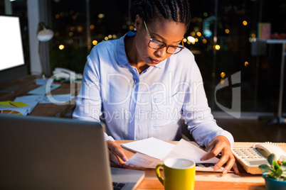 Businesswoman reading document at her desk