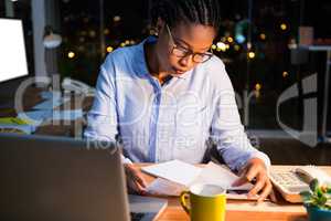 Businesswoman reading document at her desk