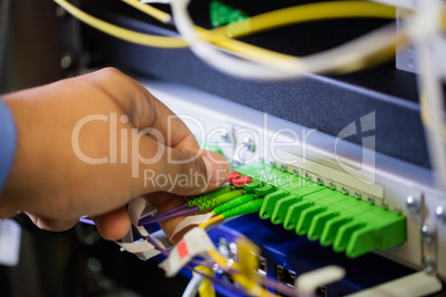 Technician plugging patch cable in a rack mounted server