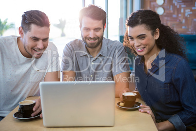 Friends using a laptop in the coffee shop