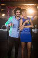 Cute couple dancing together on dance floor while having drink