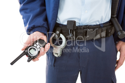 Mid section of security officer holding a walkie-talkie