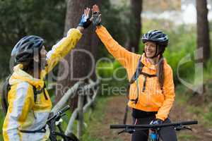 Biker couple giving high five to each other in countryside