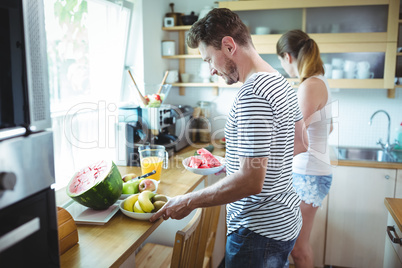 Couple preparing breakfast with fruits