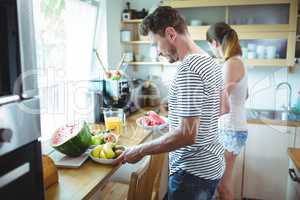 Couple preparing breakfast with fruits