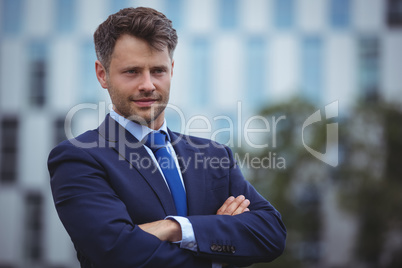 Handsome businessman standing with arms crossed