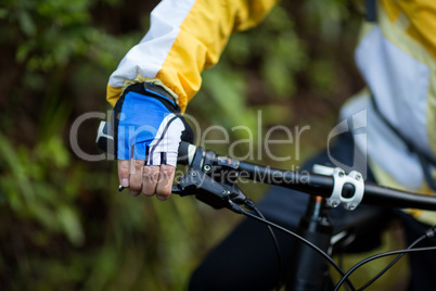 Mid-section of male biker with mountain bike