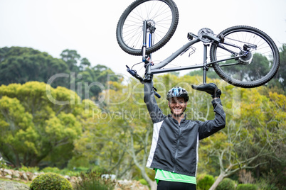 Male cyclist carrying mountain bike