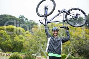 Male cyclist carrying mountain bike