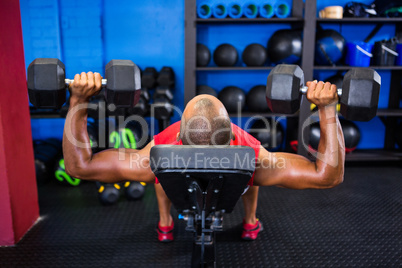 Man with dumbbells on weight bench