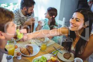 Happy woman feeding breakfast to his son